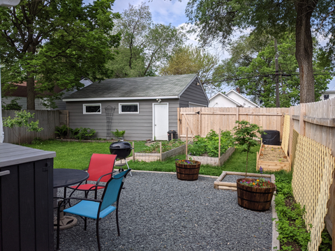 Post backyard landscaping, gravel patio and raised beds with new sod.